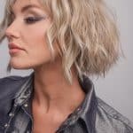 Blonde, wavy bob wig styled on a woman with a leather jacket.